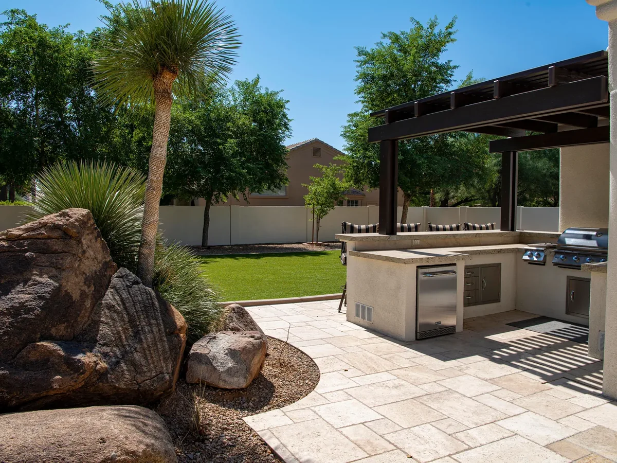 Paver patio with pergola, boulders and turf