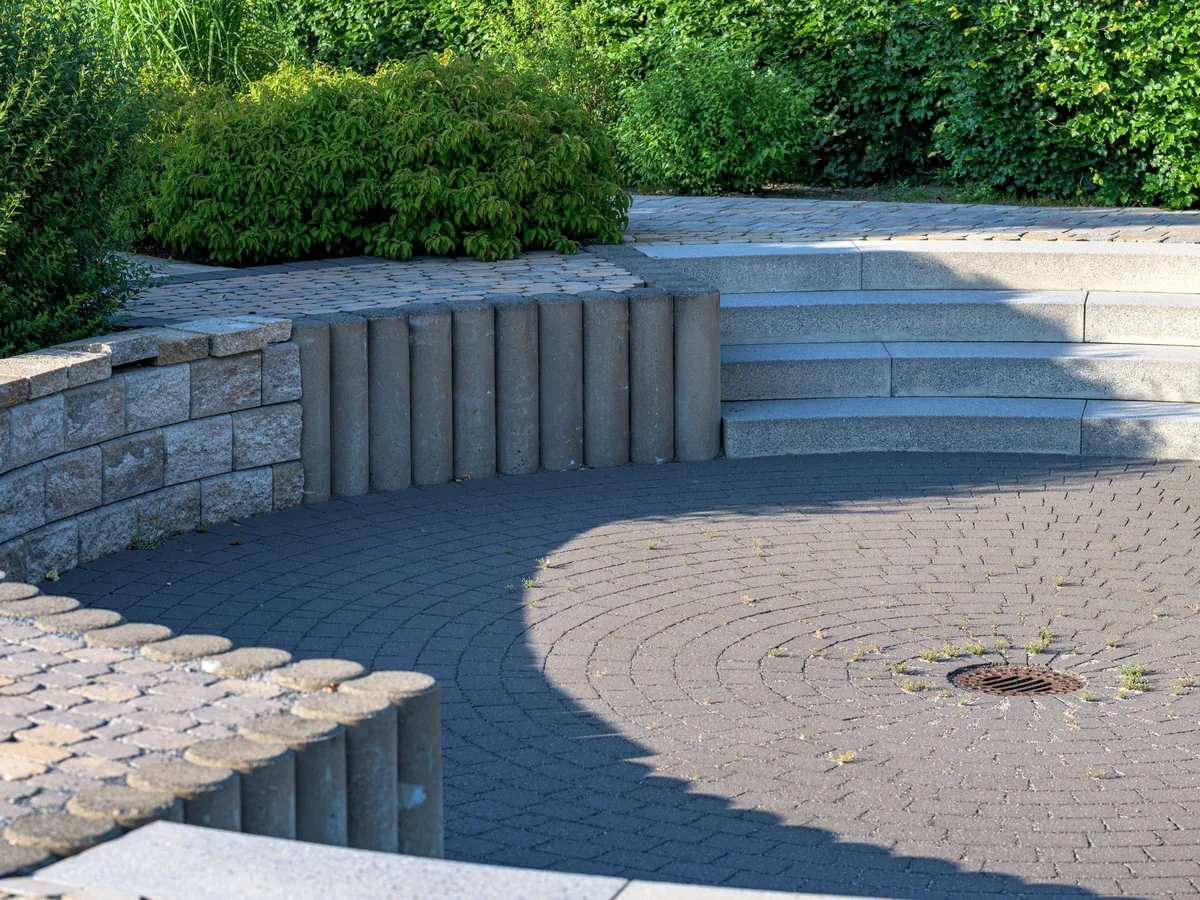 Circular paver patio with a stone retaining wall
